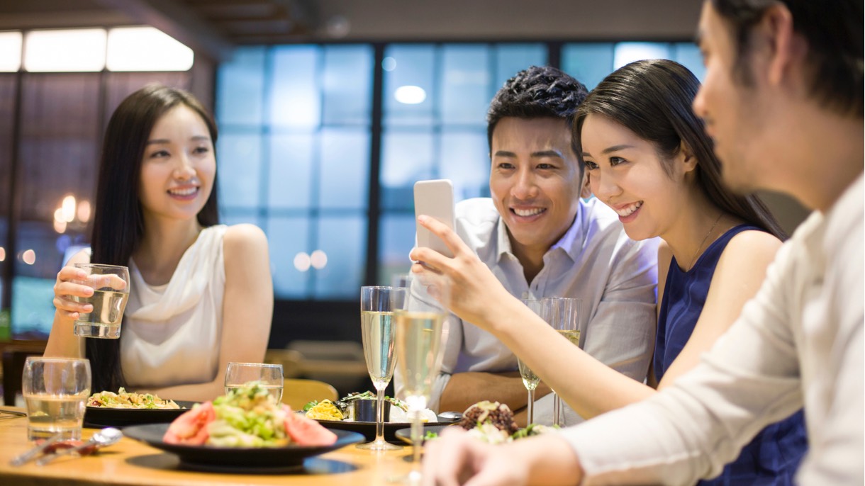 Two women smiling while looking at the smartphone