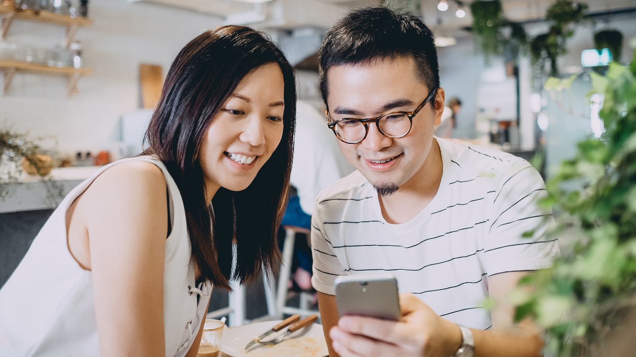 情侣在查看电话;图片使用于汇丰最红奖赏计划。