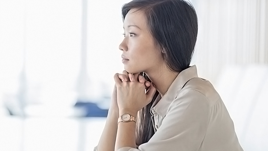 A depressed woman is praying; image used for bereavement page.